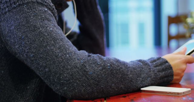 Person Wearing Sweater Using Smartphone at Cafe Table - Download Free Stock Images Pikwizard.com