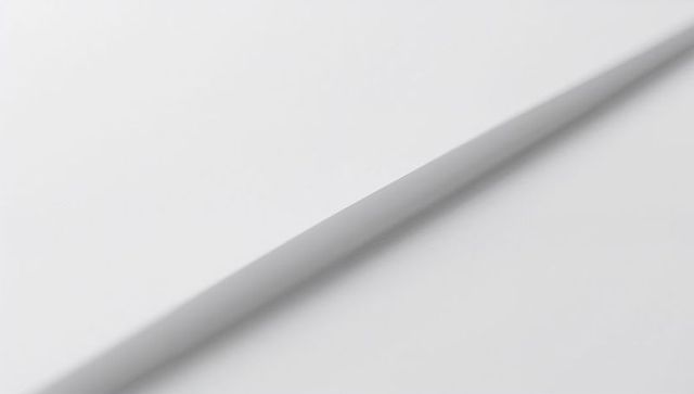 Diagonal crease on white paper creating soft shadow minimal monochrome abstract