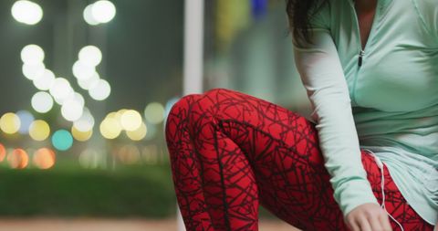 Active Urban Woman Tying Shoes at Night in Stylish Sportswear - Download Free Stock Images Pikwizard.com