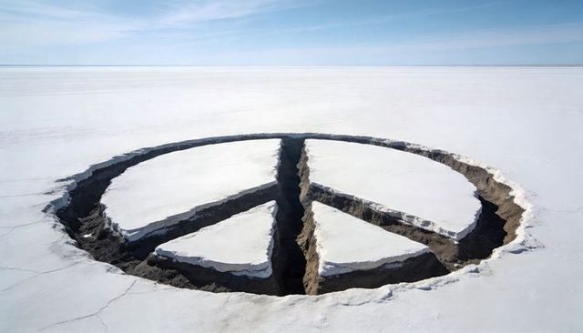 Giant peace sign cutting through salt flat revealing dark earth and deep fissures