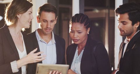 Diverse Team Engagedly Collaborating Over Document in Modern Office