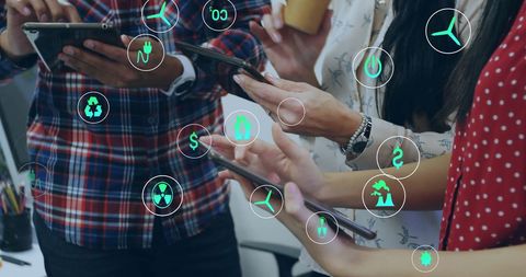 Diverse Team Using Tablets with Eco Icons Overlay