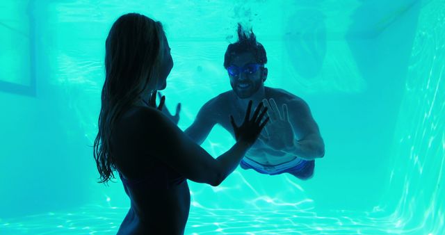 Friends Enjoying Underwater Swimming in Pool with Blue Lighting - Download Free Stock Images Pikwizard.com