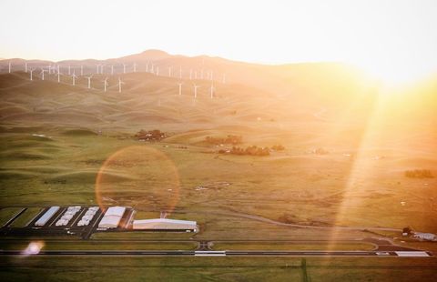 Wind turbines in a hazy countryside landscape at sunset