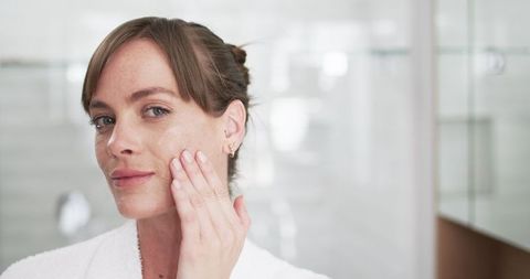 Middle-Aged Woman Applying Facial Cream in Comfortable Home Environment
