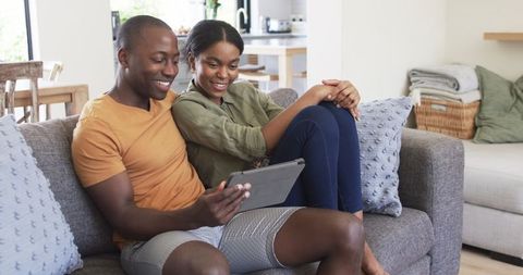 Happy Couple Enjoying Digital Content on Tablet at Home