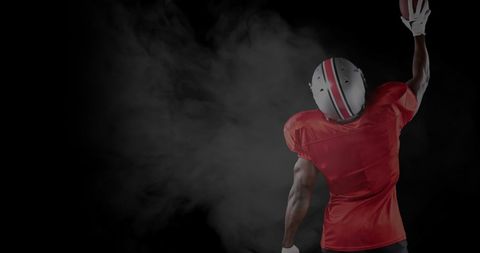 American Football Player Celebrating with Arm Raised and Mystic Smoke Background