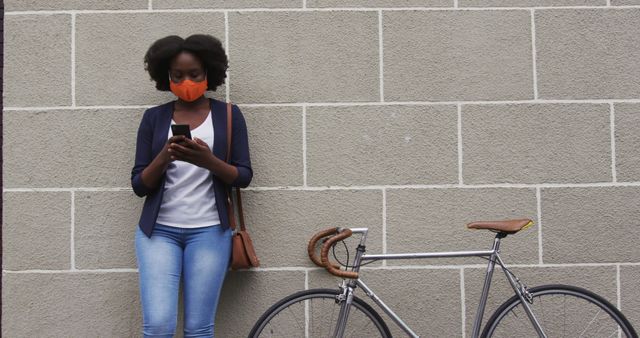 Woman Wearing COVID-19 Face Mask Using Smartphone Near Bicycle - Download Free Stock Images Pikwizard.com