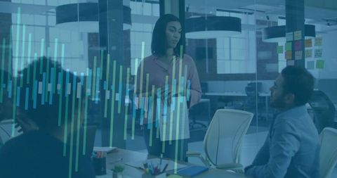 Woman leading team while presenting data visualization in modern open-plan office meeting