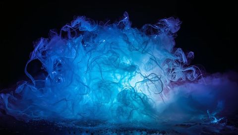 Billowing blue-purple vapor cloud glowing and curling on reflective dark surface