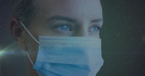 Woman Wearing Protective Mask Eyes Focused In Low Light