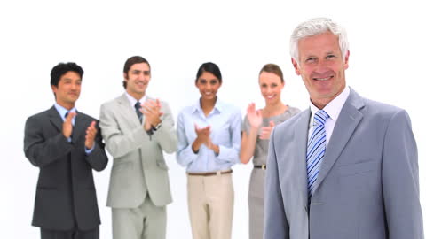 Smiling Businessman Celebrated by Colleagues in Professional Attire
