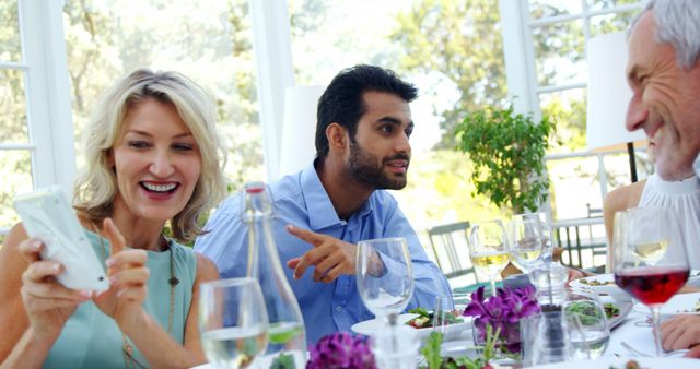 A diverse group of adults enjoys a meal together outdoors, with copy space - Download Free Stock Photos Pikwizard.com