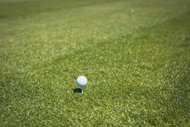 Golf ball on a tee at a golf course prepared for a shot across the green. golf sports hobby, healthy active lifestyle.