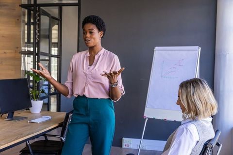 Confident Businesswoman Demonstrating Charts in Meeting