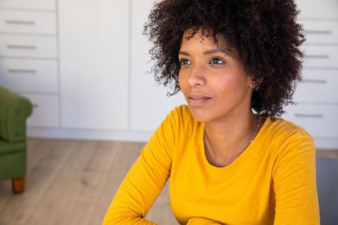 Woman in yellow sweater relaxing in cozy kitchen home interior