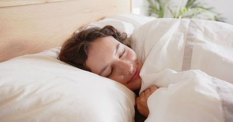 Peaceful Woman Sleeping Comfortably in Minimalist Bedroom