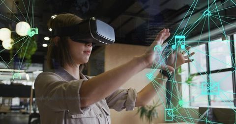 Asian woman interacting with holographic interface in modern office wearing vr headset