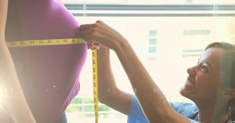 Careful Doctor Measuring Pregnant Woman’s Belly in Clinic Setting