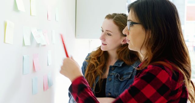 Two Women Collaborating Planning Ideas on Sticky Notes Wall - Download Free Stock Images Pikwizard.com