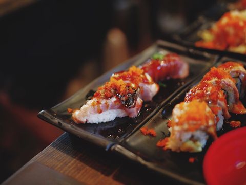 Gourmet Sushi Rolls with Spicy Toppings on Black Plate