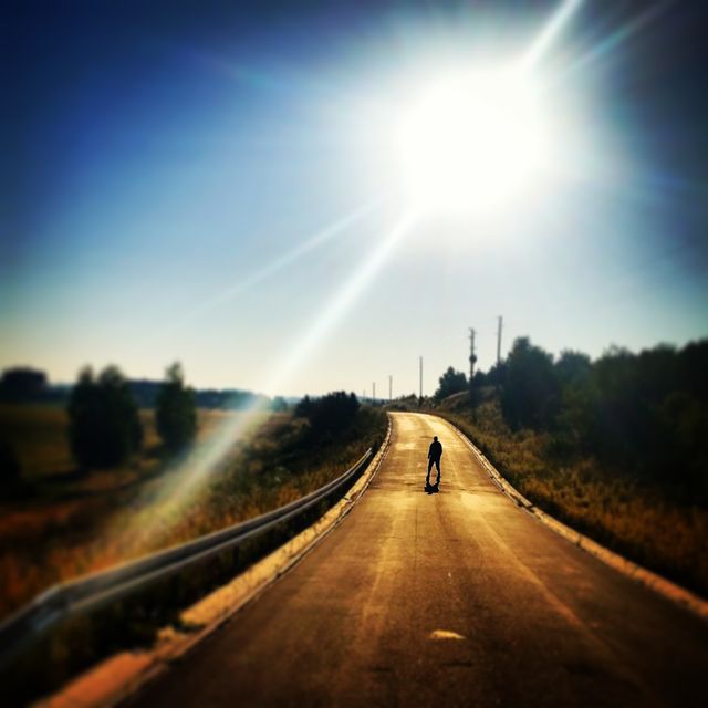 Person Walking Alone on Country Road with Bright Sunlight - Download Free Stock Photos Pikwizard.com