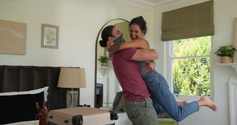 Joyful Couple Packing for Romantic Getaway in Bright Room