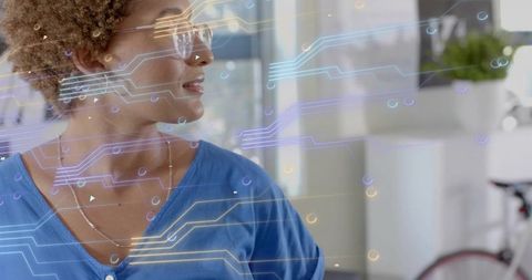 Woman wearing smart glasses exploring augmented reality in modern office