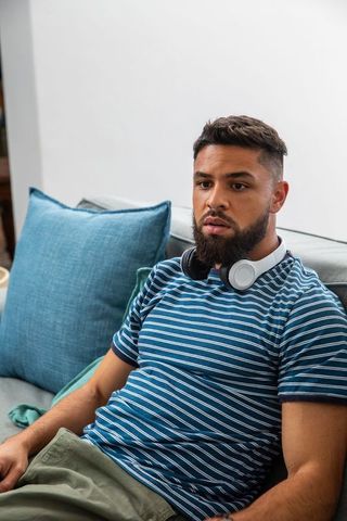 Relaxed man wearing headphones at home on cozy sofa