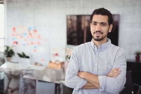 Confident Professional Posing in Modern Creative Office Environment