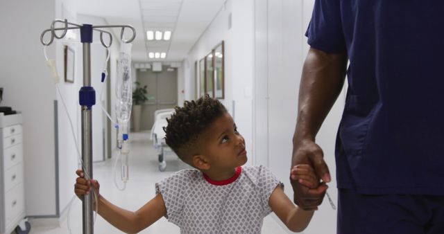African american male doctor walking with child patient at hospital. Medicine, healthcare, lifestyle and hospital concept.