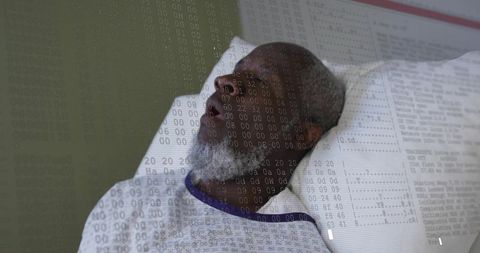 Senior male patient lying on hospital bed with numeric overlay representing medical records