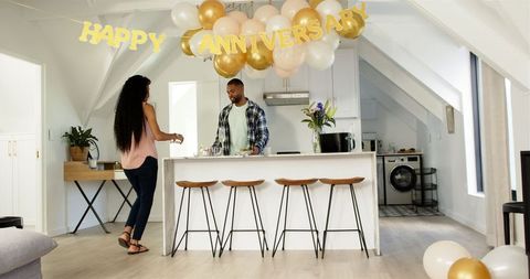 Couple Tidying Up After Cozy Anniversary Celebration at Stylish Home
