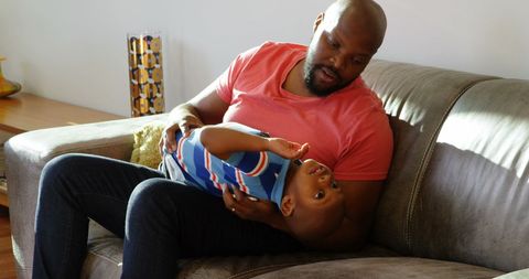 African American Father Bonding with Son in Living Room