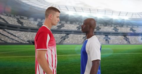 Soccer Players Facing Off on Green Field in Large Stadium