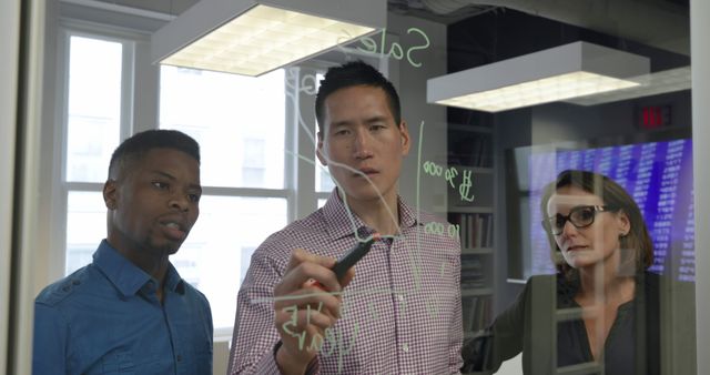 Diverse Business Team Analyzing Data and Writing on Glass Wall in Modern Office - Download Free Stock Images Pikwizard.com