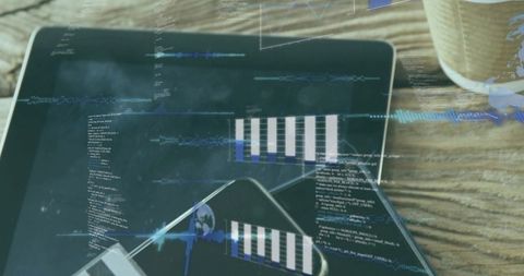 Futuristic tablet and smartphone showing code, waveforms and analytics on wooden tabletop