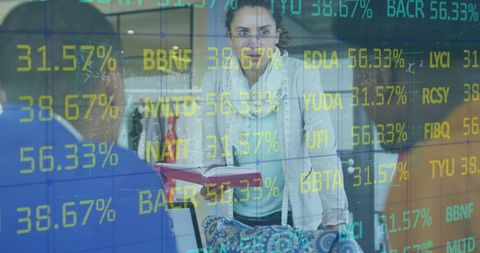 Diverse designers collaborating over stock market digital overlay