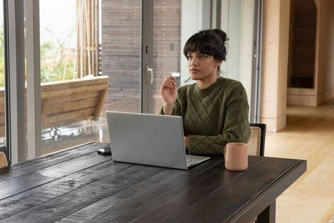 Young Woman Working from Home Wearing Casual Green Sweater