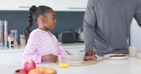 African american father and daughter sharing cozy morning breakfast at kitchen counter