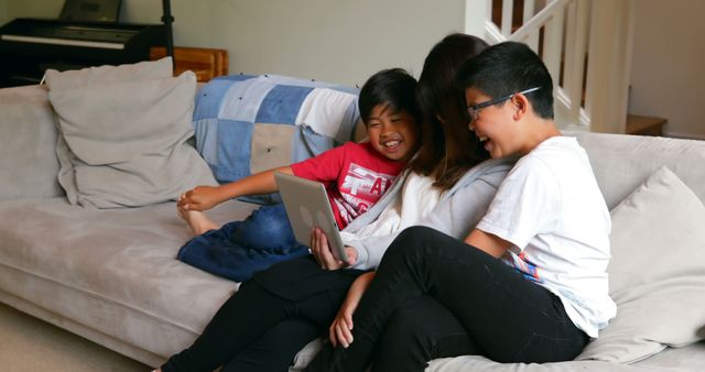 Happy Family Relaxing on Sofa Sharing Tablet Screen Together - Download Free Stock Images Pikwizard.com