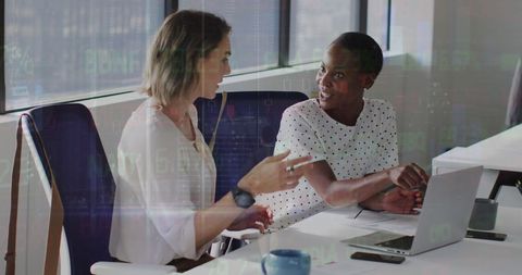 Diverse Female Coworkers Discussing Financial Data in Modern Office