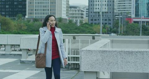 Stylish Woman in Cityscape Talking on Smartphone