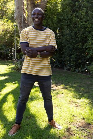 Smiling Man Enjoying Outdoor Leisure in Striped T-shirt and Jeans