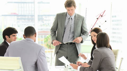 Businessman Presenting to Multiethnic Team in Modern Office