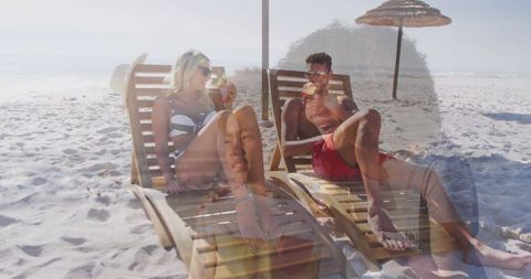 Couple relaxing with coconut drinks on sunny beach