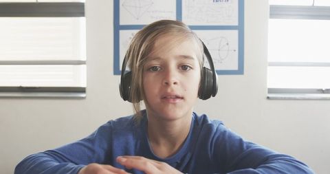 Schoolboy focused with headset in study space