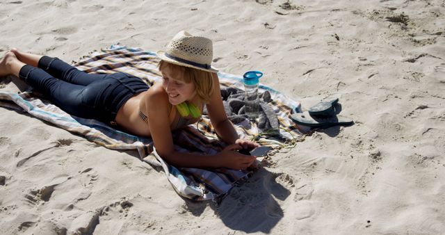 Boy Relaxing on Beach Towel with Smartphone and Hat - Download Free Stock Images Pikwizard.com