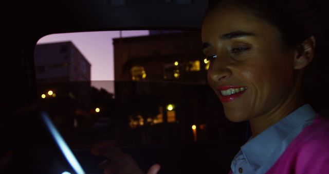 Woman Smiling While Using Smartphone in Car at Night - Download Free Stock Images Pikwizard.com