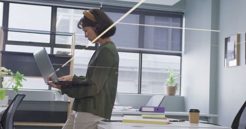 Professional Woman Using Laptop in Modern Office Setting